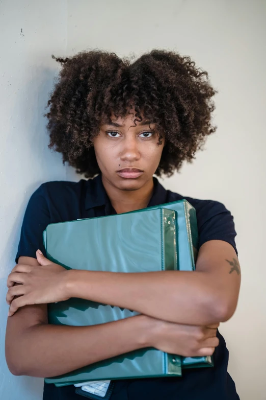 a man holding a folder next to his face