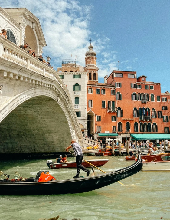 a man is riding in a boat in front of a bridge