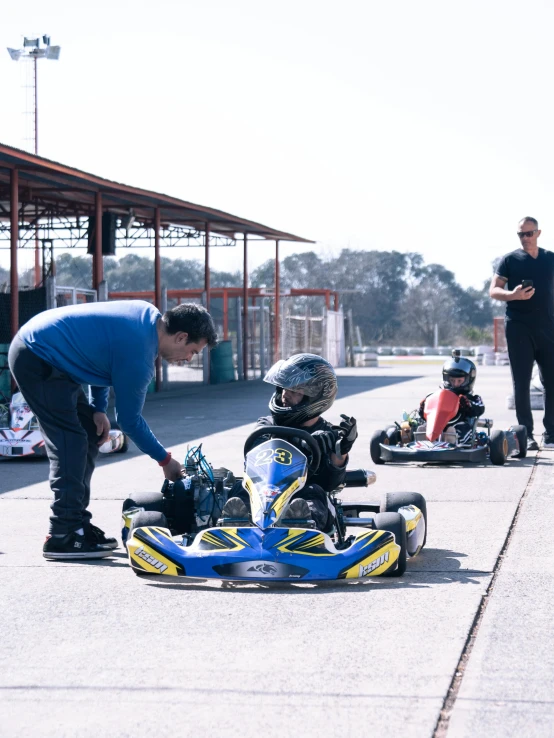 a man is helping children who are riding go - carts