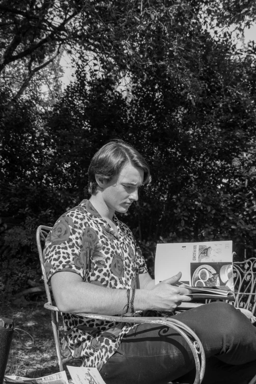 a woman sitting in a chair working on an open book