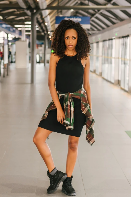 the young lady is posing on the train platform