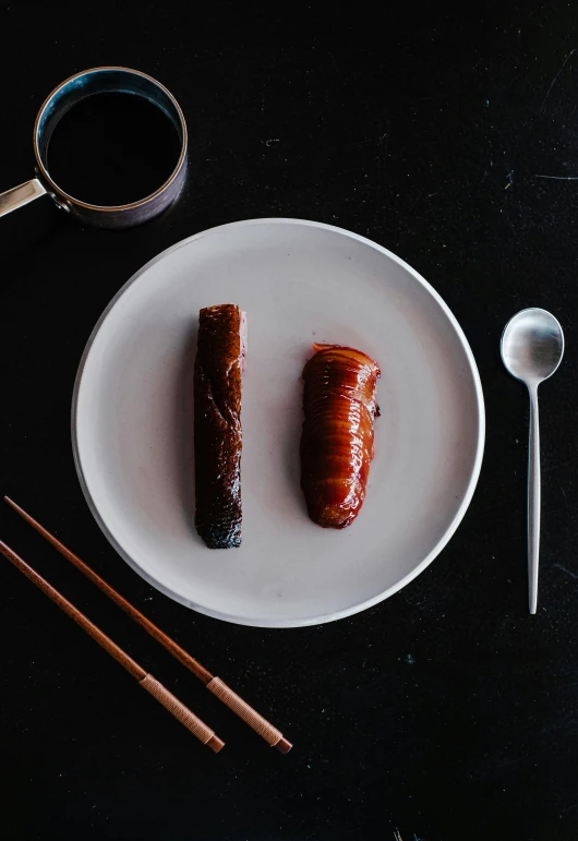 a plate with chopsticks and an opened  dog on it