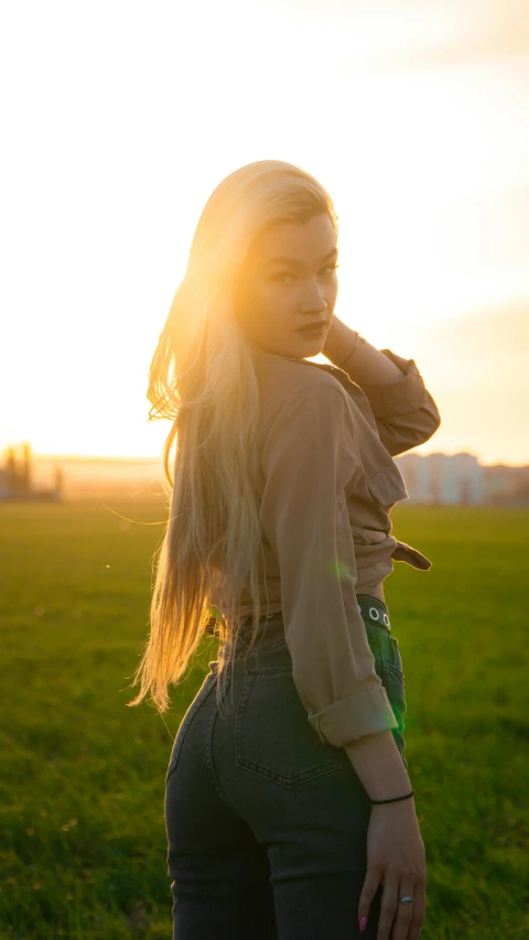 a young lady stands on a field with long hair