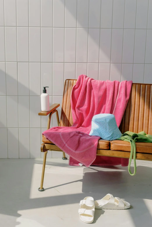 a bench with a towel on it next to a bath towel