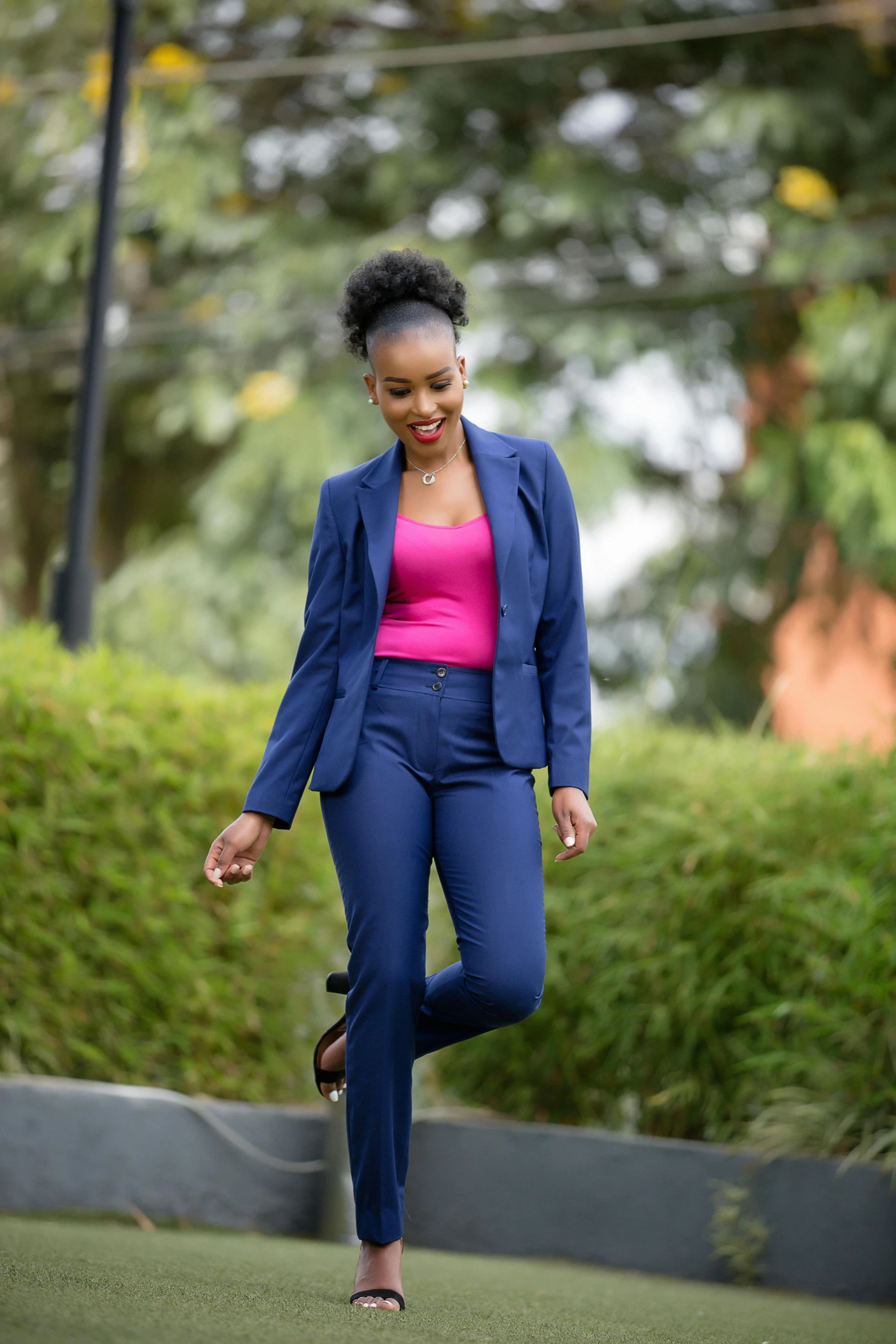 woman in bright pink shirt and blue suit running