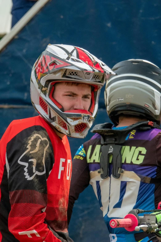 two young men with protective gear and helmets talking