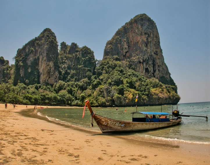 an old boat is docked on a beach near the sea