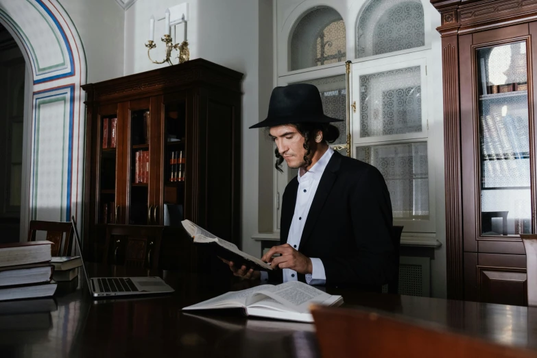 a man wearing a hat while reading some paper