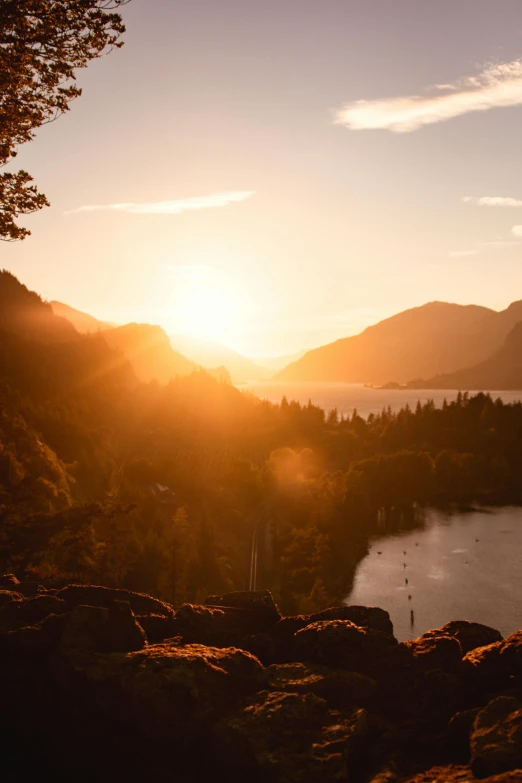 a view of a sun setting over a mountain lake