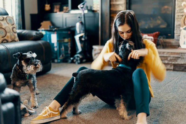 a lady with a dog in her lap and sitting on the floor