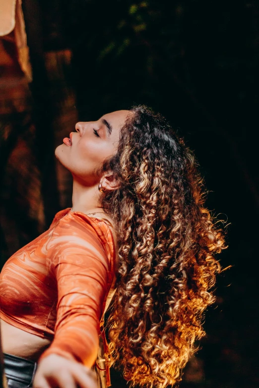 a woman in orange and black holding her hands together