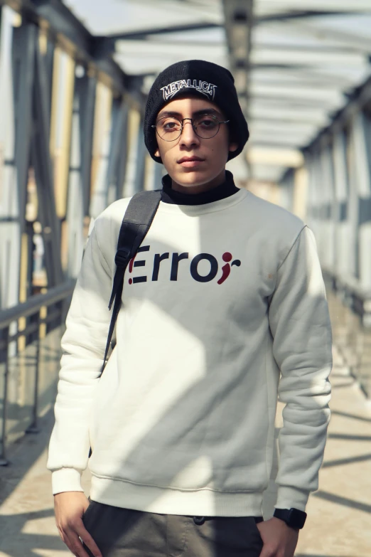 a young man in glasses and a hat posing