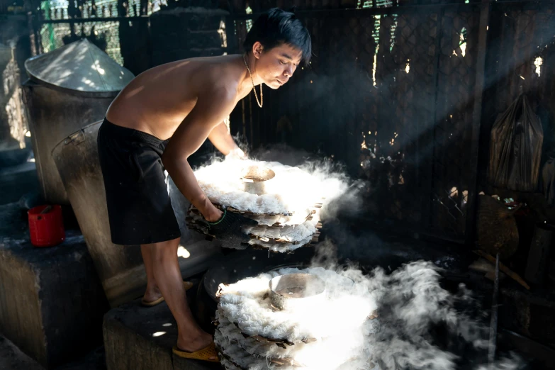 a man standing over a large pot filled with white stuff