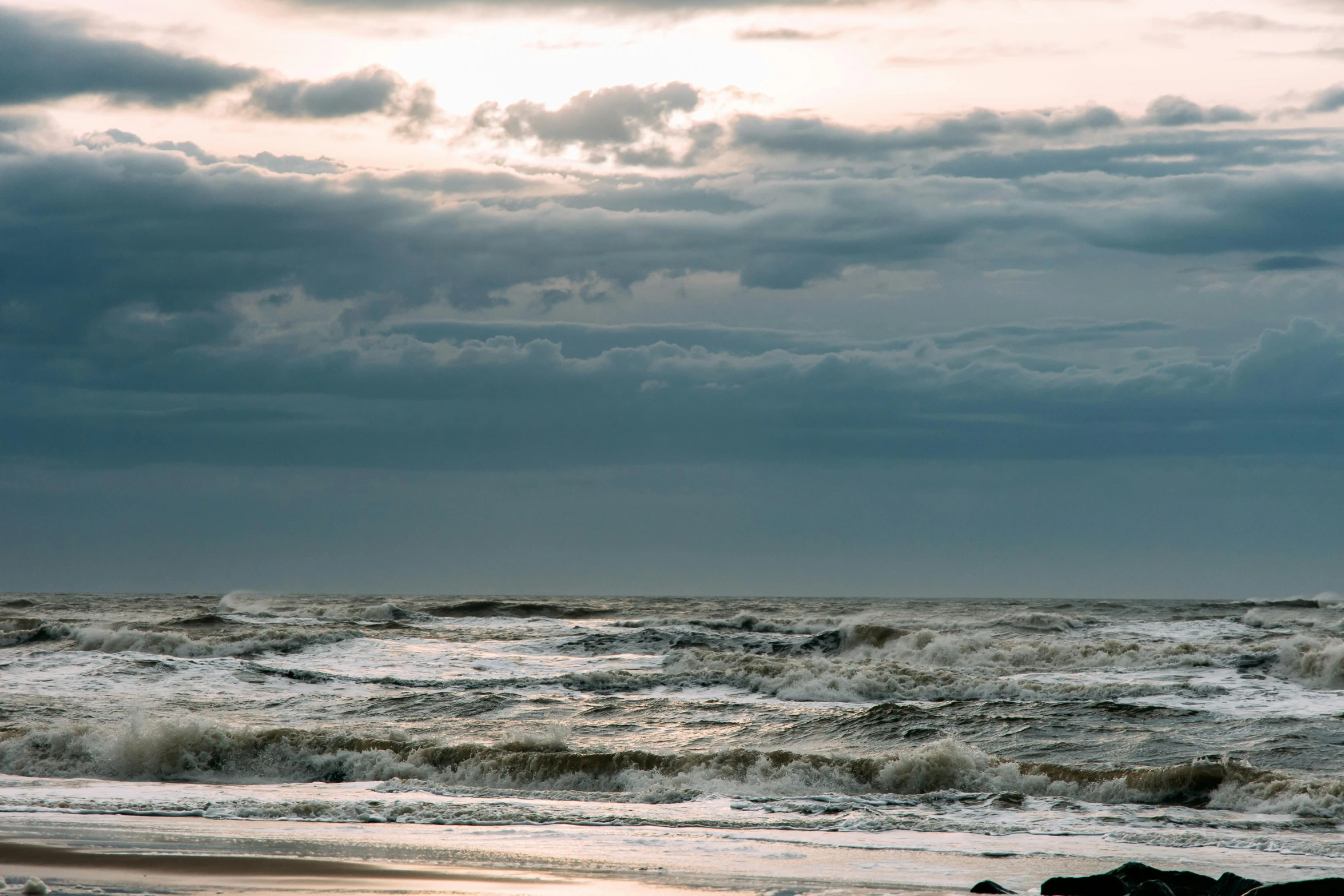 the waves wash ashore on the sandy beach