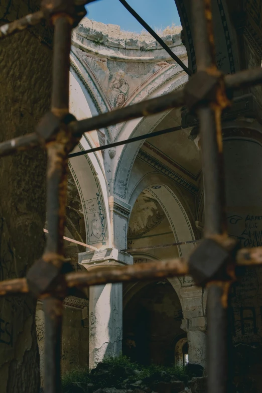 view of an arches and columns through a fence