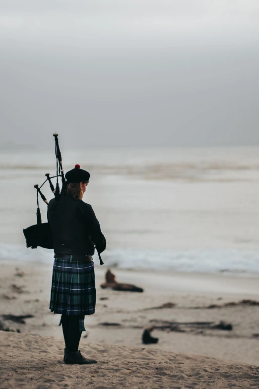 the bagpipe player is at the beach playing