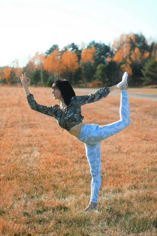 a woman in camouflage dancing on the grass