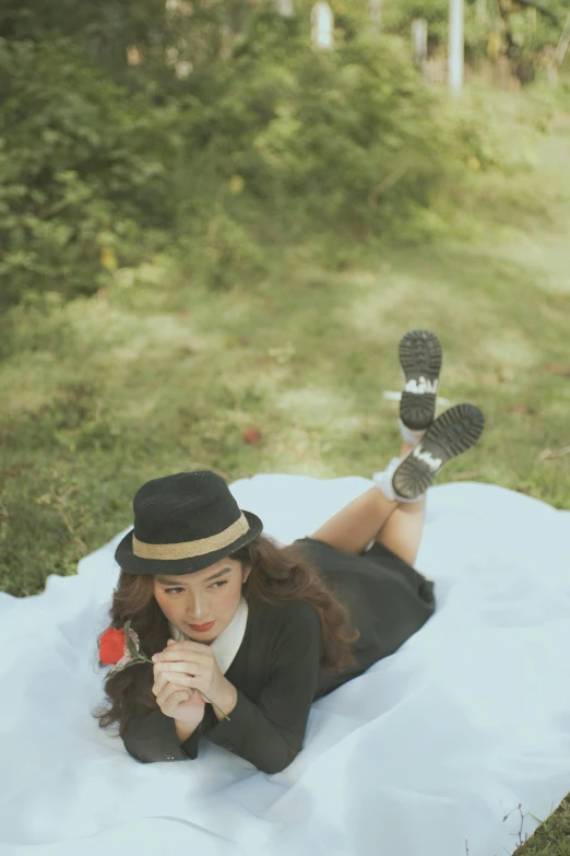 a beautiful woman laying on a blanket while wearing shoes