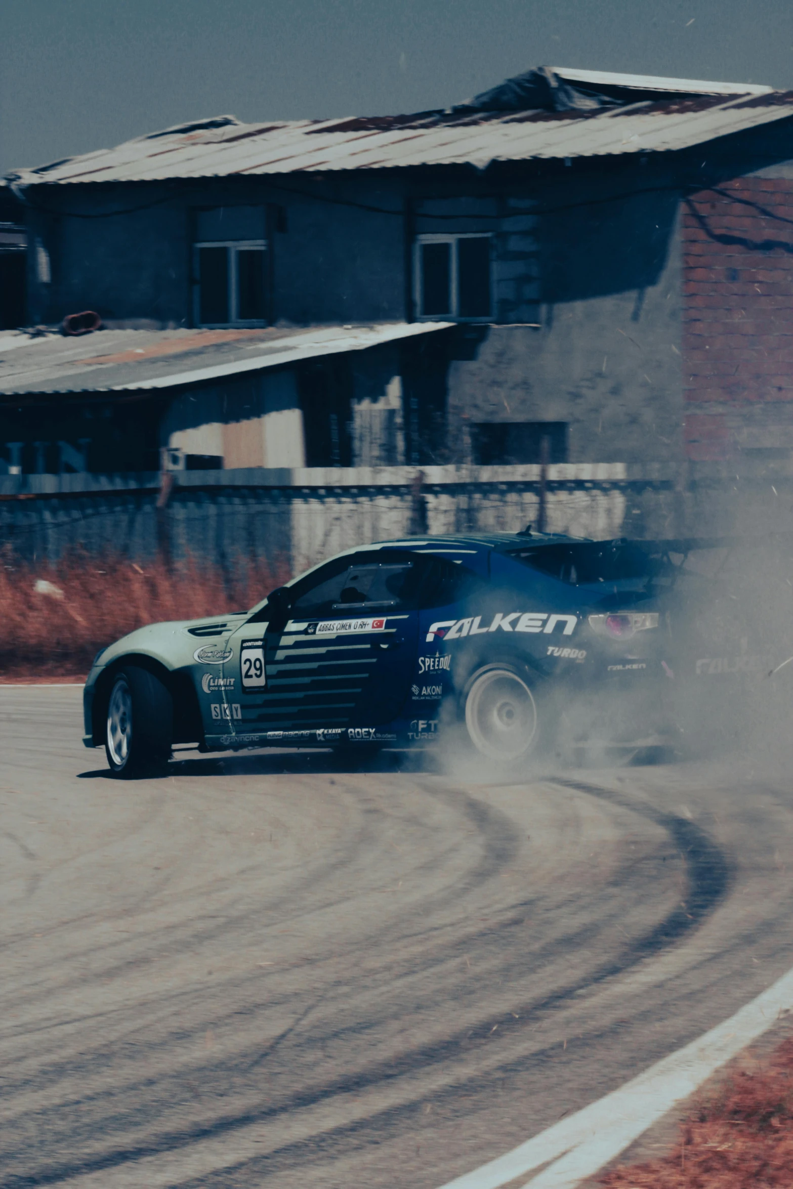 a car driving on a road with a dust cloud in front of it