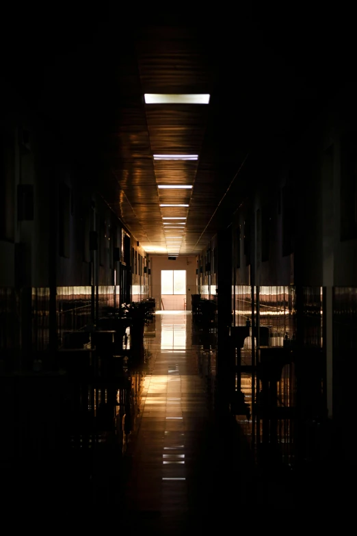 a long dimly lit hallway with dark floors