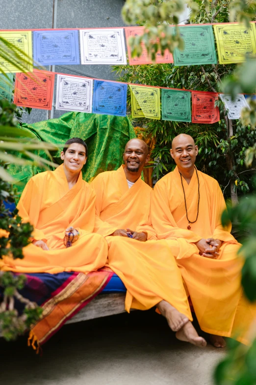 some people sitting in front of a bunch of hanging items