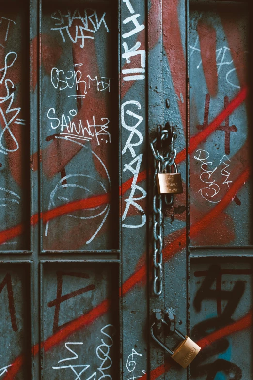 some graffiti is seen on a wall, with padlocks