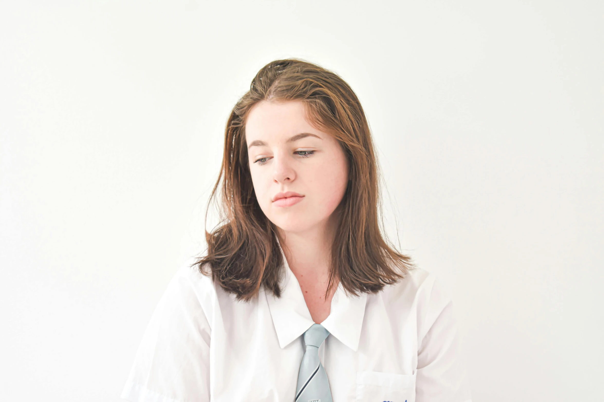 a woman wearing a tie standing in a white room