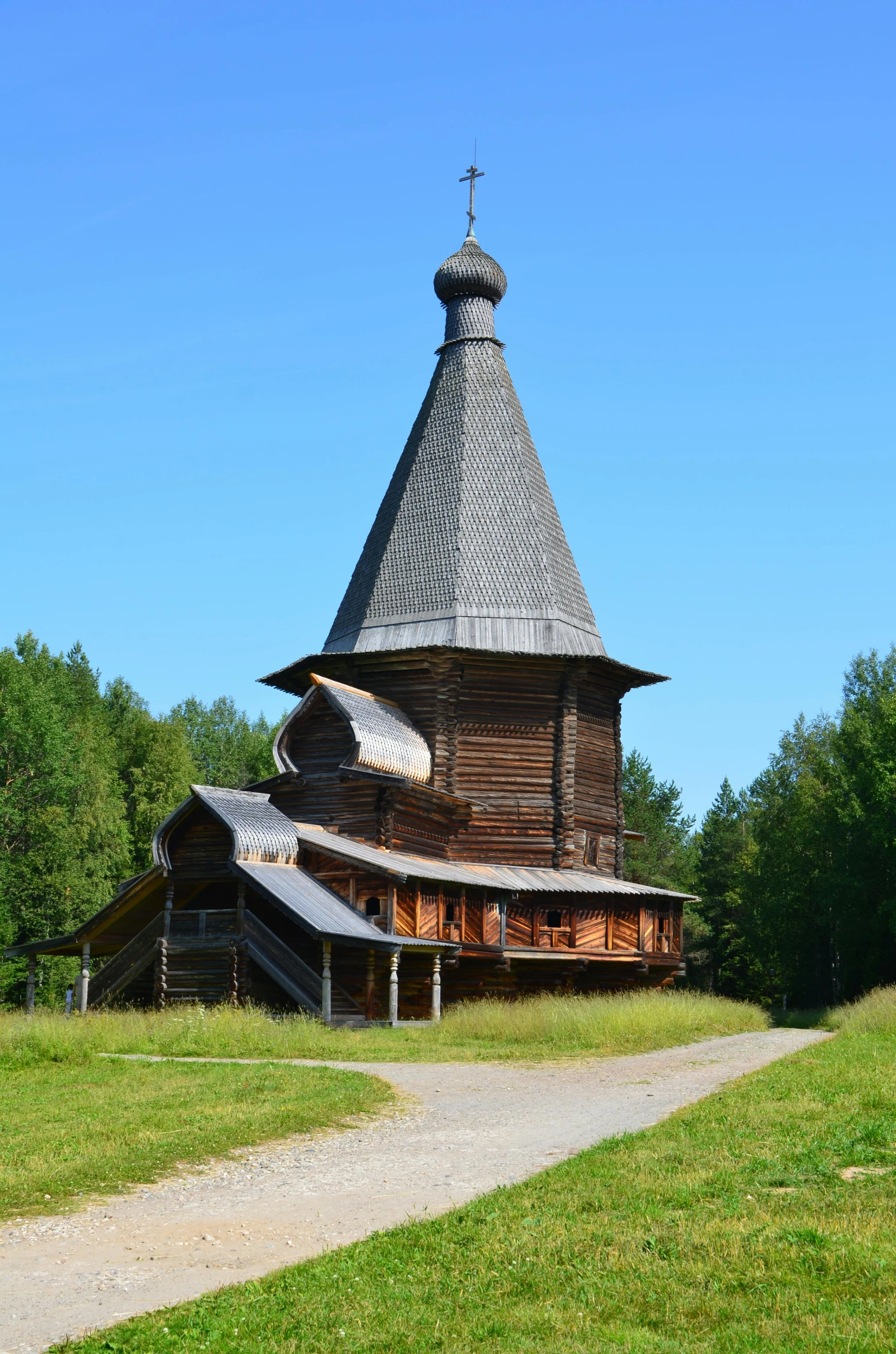 an old church in an open field near a wooded area