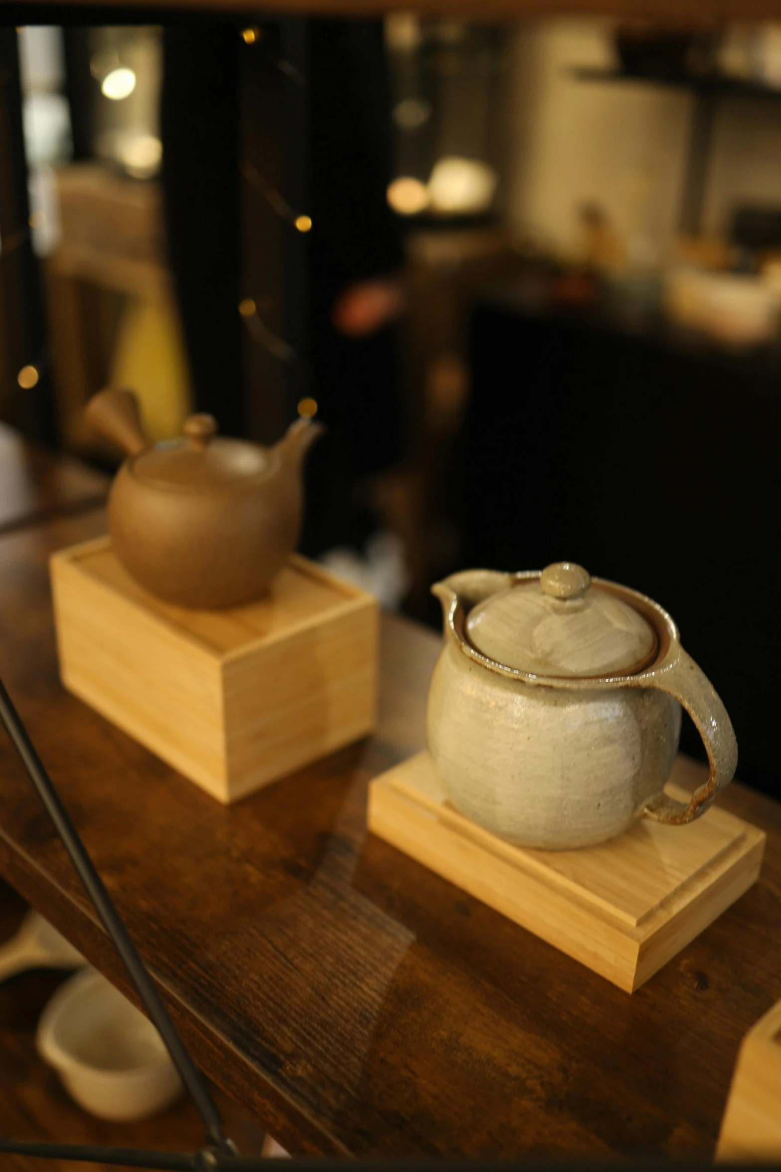 two small pieces of pottery on a table with wooden stand