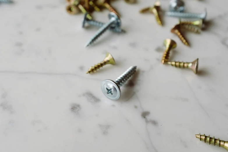 an assortment of screws sitting on a white counter