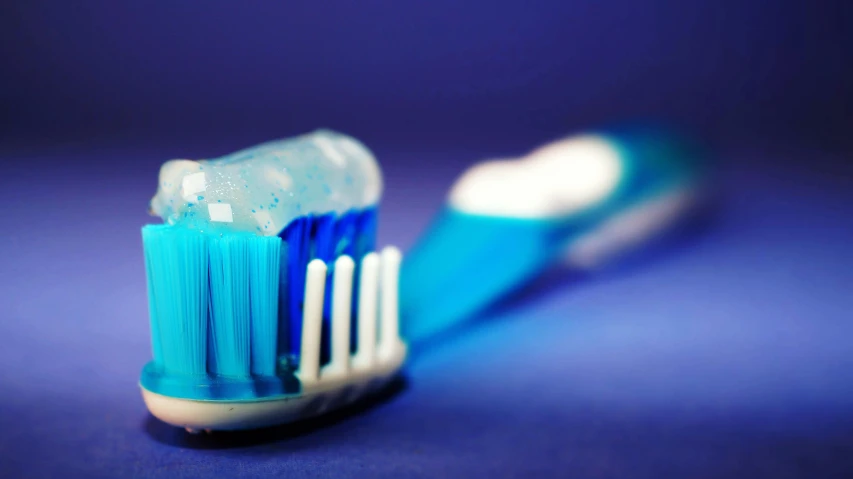 an electric toothbrush laying on its side on a blue surface