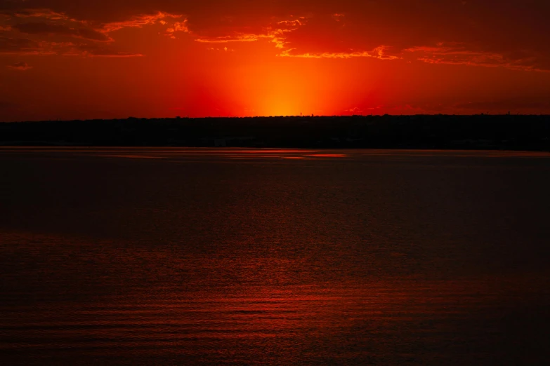 a beautiful sunset with bright red sky over water