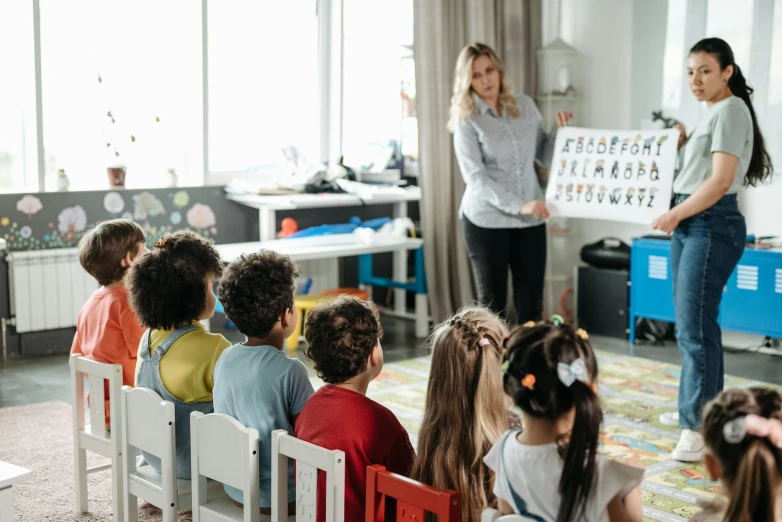 an adult teacher is giving a lesson to the children in a classroom