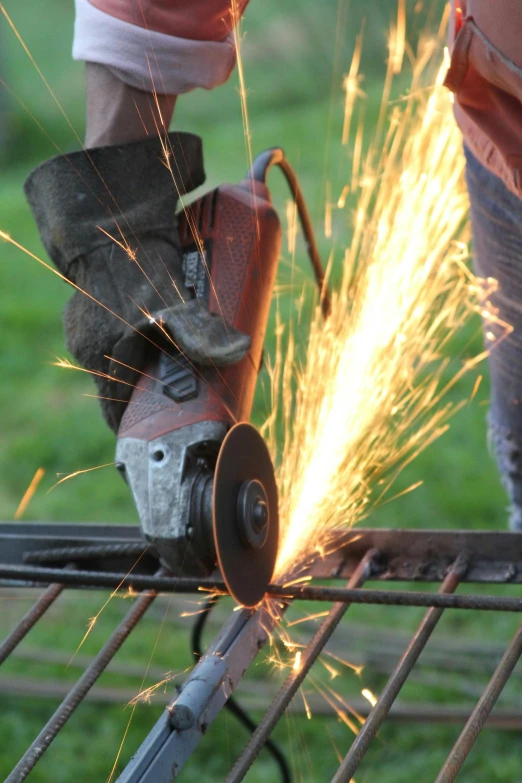 an electric welder cuts a metal wire fence