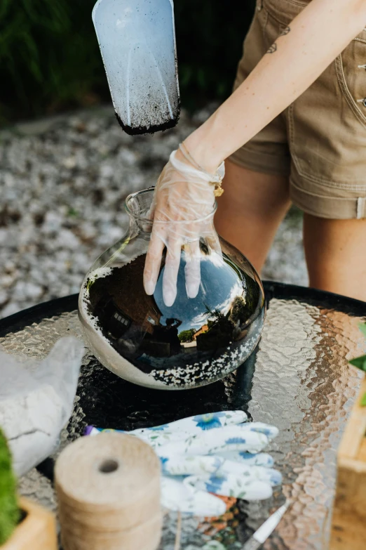 a woman in a yellow shirt is cleaning up an outdoor table