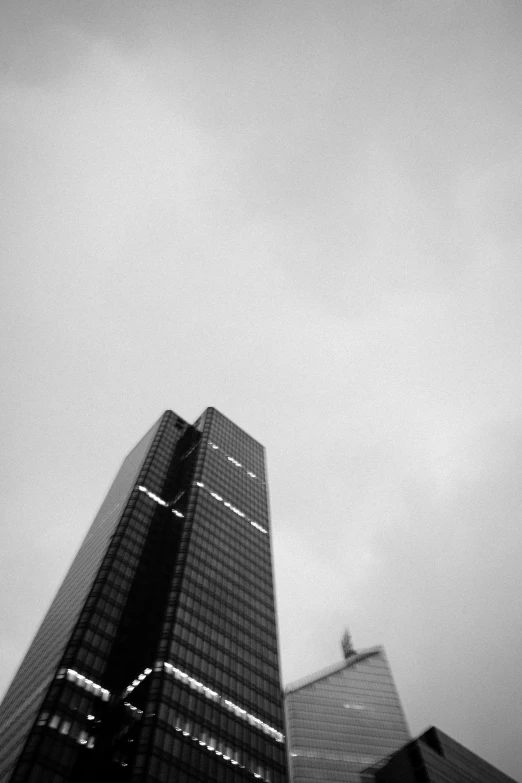 a bird sitting on top of a pole near tall buildings