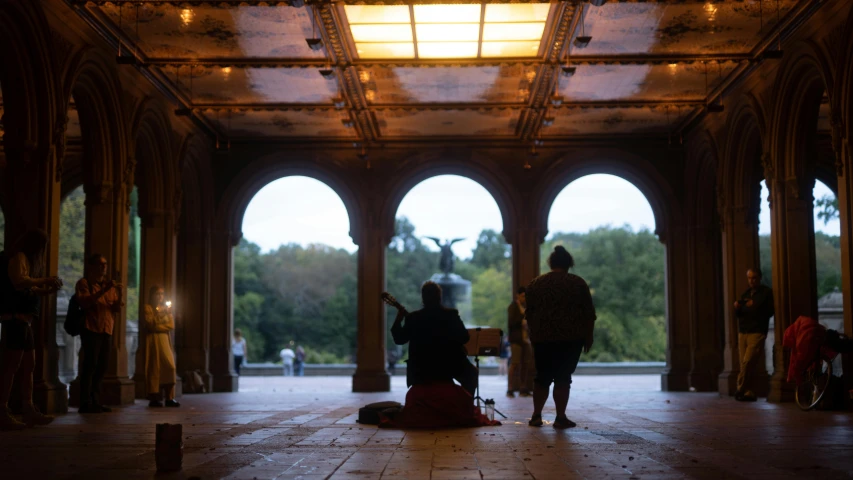 people are standing in a building while two look out windows