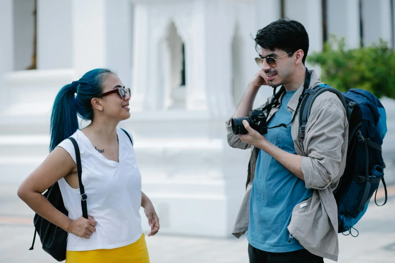 two people on the street talking and one is taking a picture