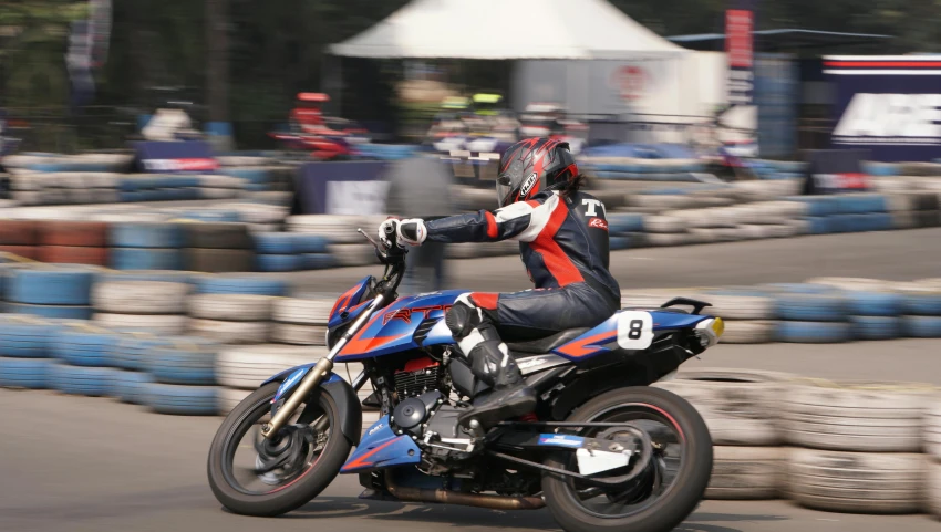 the racer is racing on his motorcycle around tires