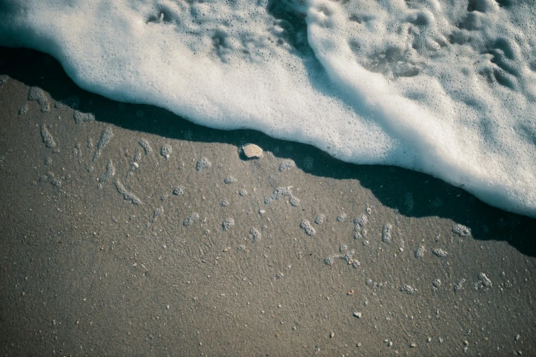 a message that reads beach written in the sand