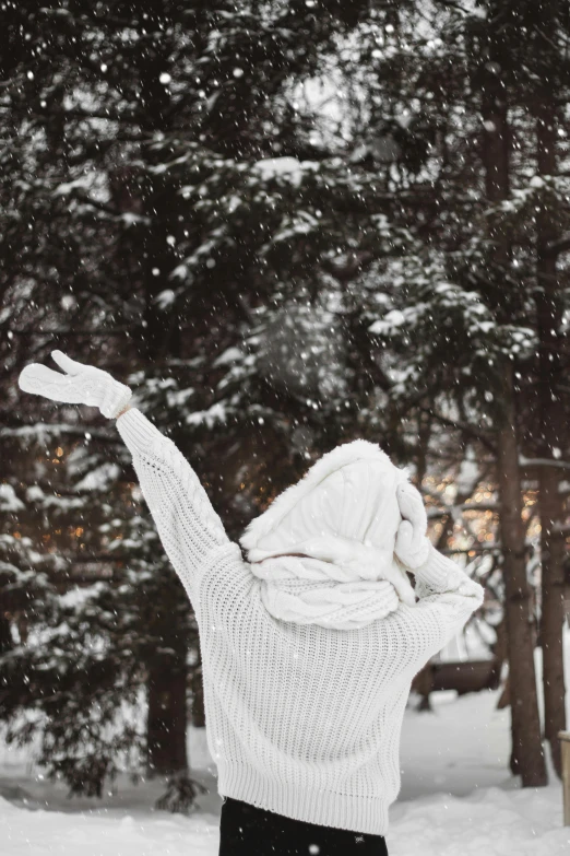 a person on a snowboard holding their arms up in the air