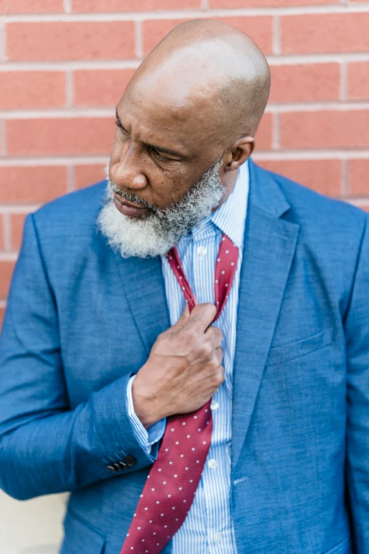 an african american man in a suit fixes his tie