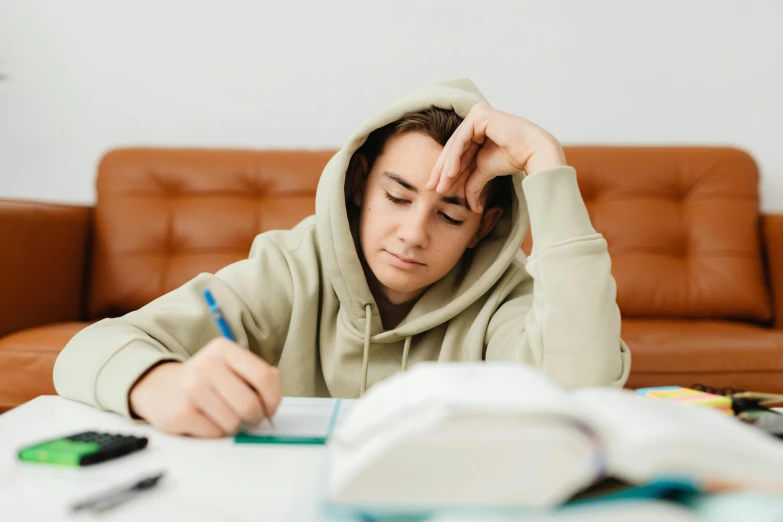 man at a desk writing on a notebook and taking notes