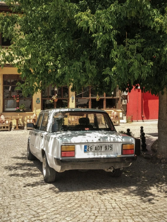 this is a car parked next to a tree