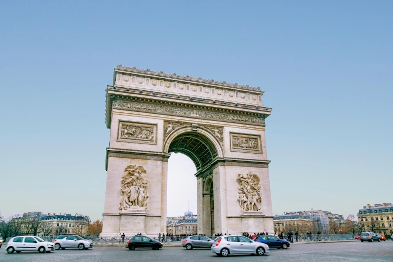 cars are driving under the arc in paris