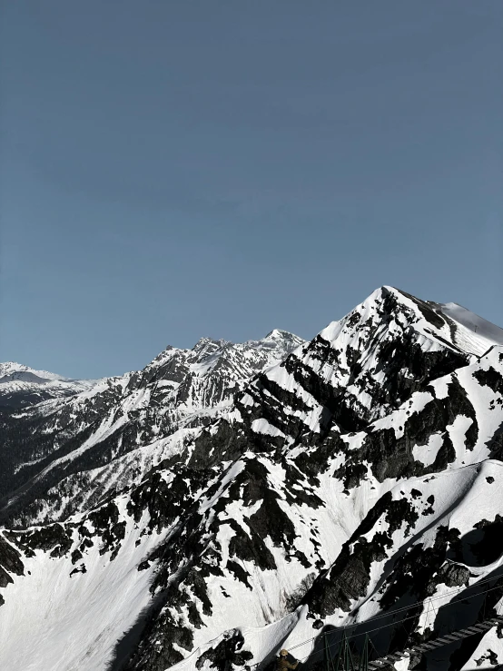 two skiers are walking up a steep mountain