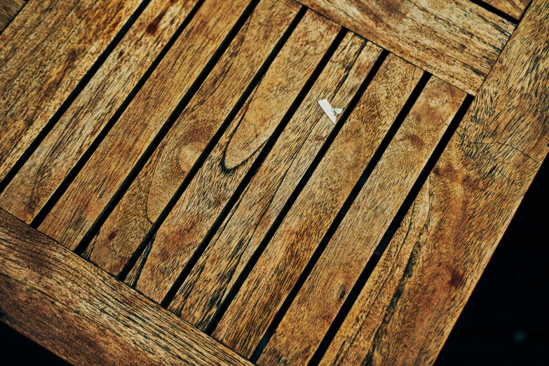 a closeup po of wooden planks from an outdoor table