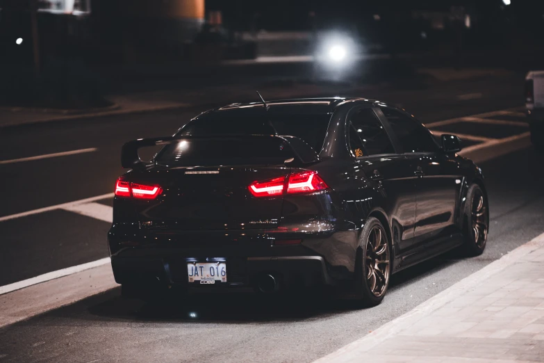 a black car that is parked in the street