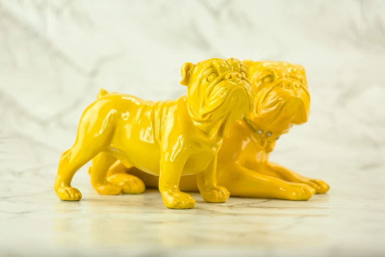 a yellow figurine of a dog with a leash in its mouth