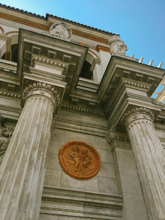 an intricate architectural building features pillars and a round stone window